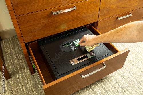 Hand opening safe in hotel room to store valuables