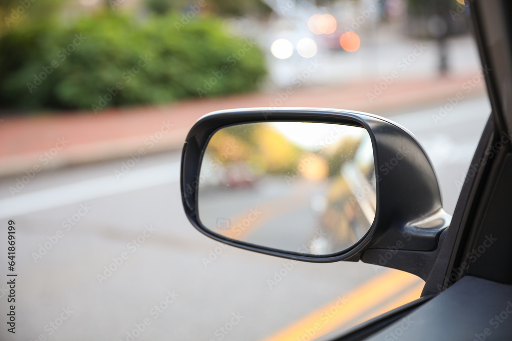 Car mirror reflects paths behind, a symbol of retrospection, foresight, and self-awareness, capturing life's rearview lessons
