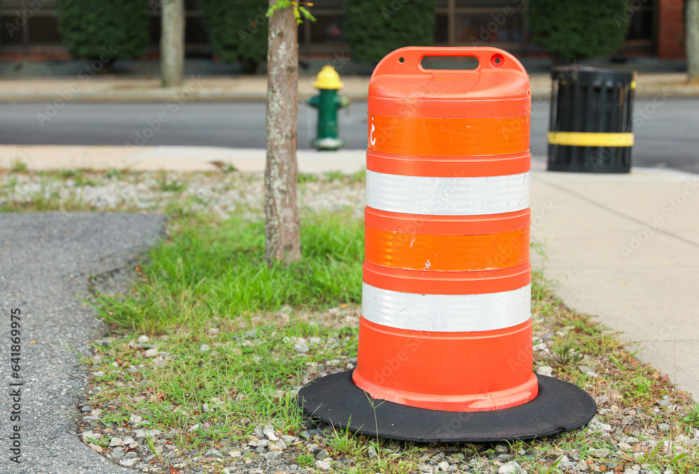 construction cone on the road signifies ongoing progress, caution, and temporary disruption in the journey ahead