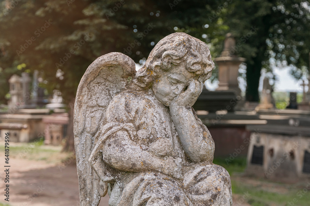 Little angel crying. Old stone statue. (concept children's mortality)