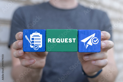 Man holding colorful blocks with icons and sees text: REQUEST. Concept of business, finance requests. Online submission, web request.