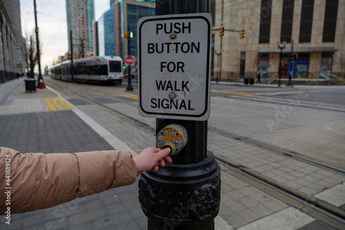 Young girl pressing button to walk across Train crosswalk in Jersey City New Jersey USA. High quality photo photo