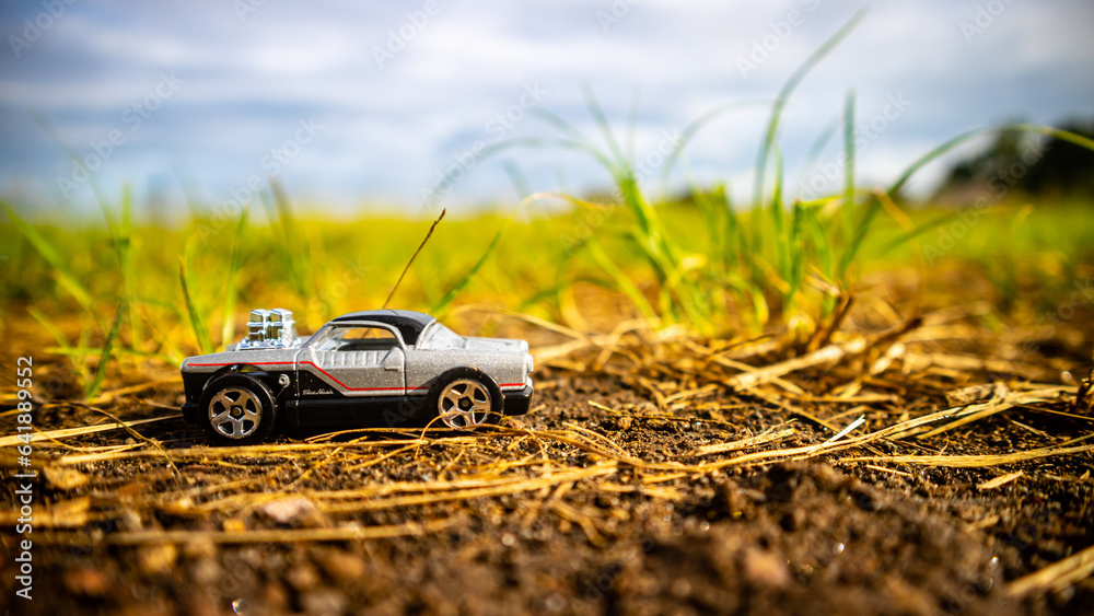 South Minahasa, Indonesia - February 1, 2023: toy car on green grass South Minahasa, Indonesia - February 1, 2023: toy car on green grass