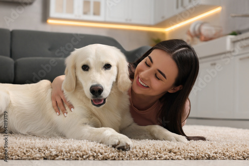 Fototapeta Naklejka Na Ścianę i Meble -  Happy woman with cute Labrador Retriever dog on floor at home. Adorable pet