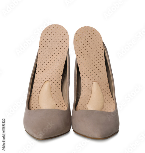Orthopedic insoles in high heel shoes on white background