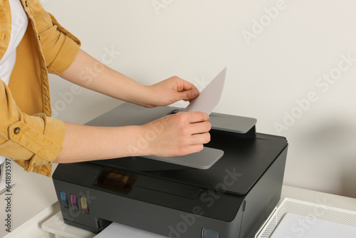 Woman using modern printer at home, closeup