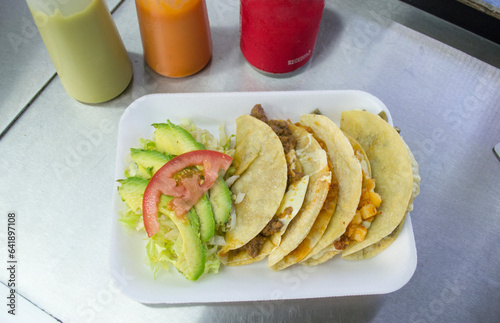 Tacos de maíz con guisados mexicanos, lechuga, aguacate y tomate. comida callejera en México. 
