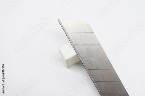 This large sized silver colored cutting knife made of metal is photographed on the isolated white background
