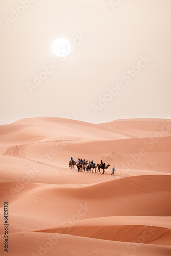 Camel trek during sunrise with tourists in the sahara desert, Merzouga Morocco