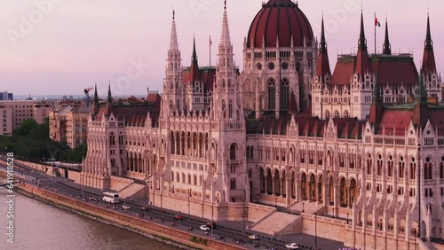 Fly around beautiful historic Hungarian parliament building lit by sunset light. Large breath taking decorated government building. Budapest, Hungary