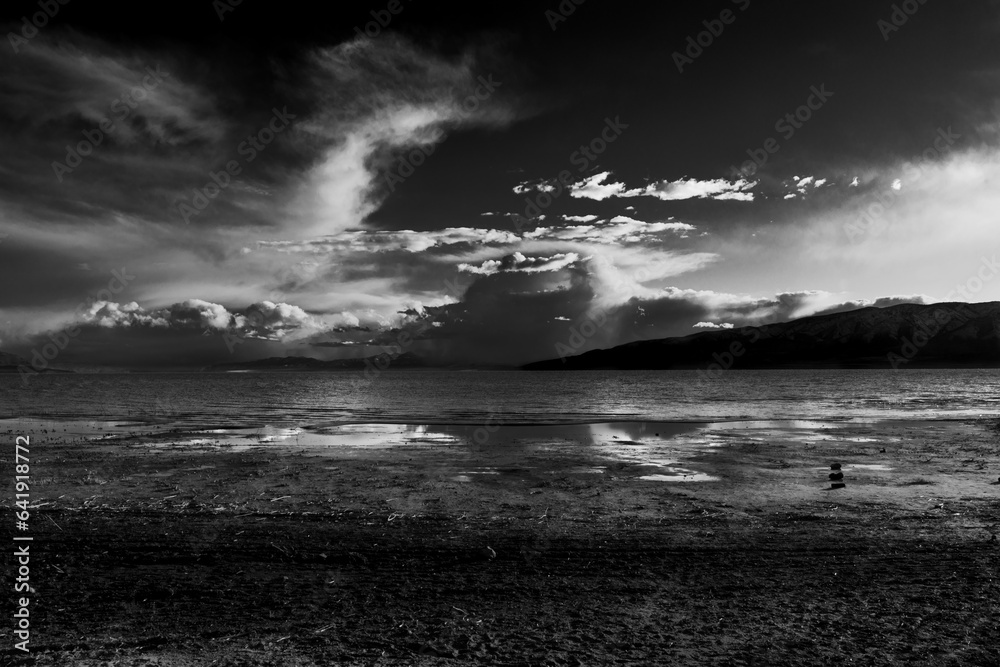dark clouds on the other side of a lake, monochrome