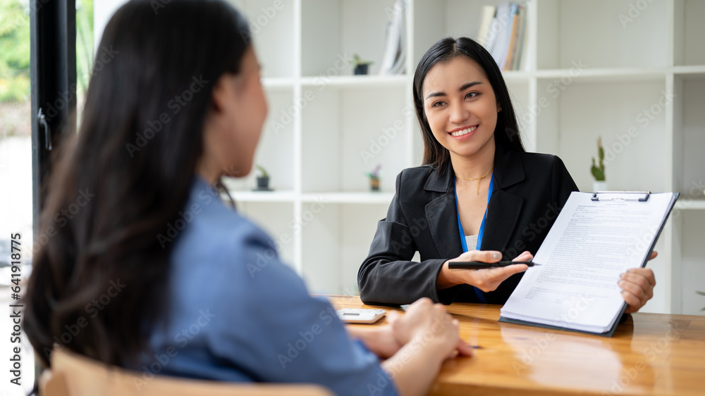 A businesswoman or sales agent is explaining the contract agreement while having a meeting A businesswoman or sales agent is explaining the contract agreement while having a meeting