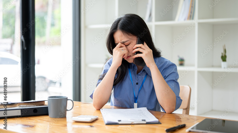 A stressed businesswoman is feeling overwhelmed, and having a serious conversation over the phone A stressed businesswoman is feeling overwhelmed, and having a serious conversation over the phone