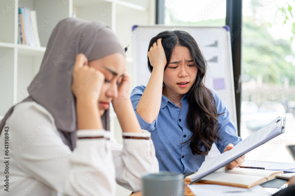A dissatisfied businesswoman is complaining about the project's mistakes to her Muslim employee