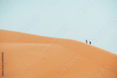 People climbing Erg Chebbi dunes in Sahara Desert  Merzouga  Morocco