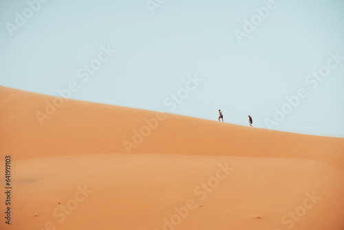 People climbing Erg Chebbi dunes in Sahara Desert  Merzouga  Morocco
