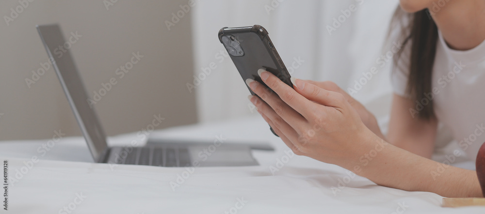 Efficient Young Millennial Girl Sitting on a Bed in the Morning, Uses Laptop Computer and Eats Croissants and Drinks Coffee for Breakfast Efficient Young Millennial Girl Sitting on a Bed in the Morning, Uses Laptop Computer and Eats Croissants and Drinks Coffee for Breakfast