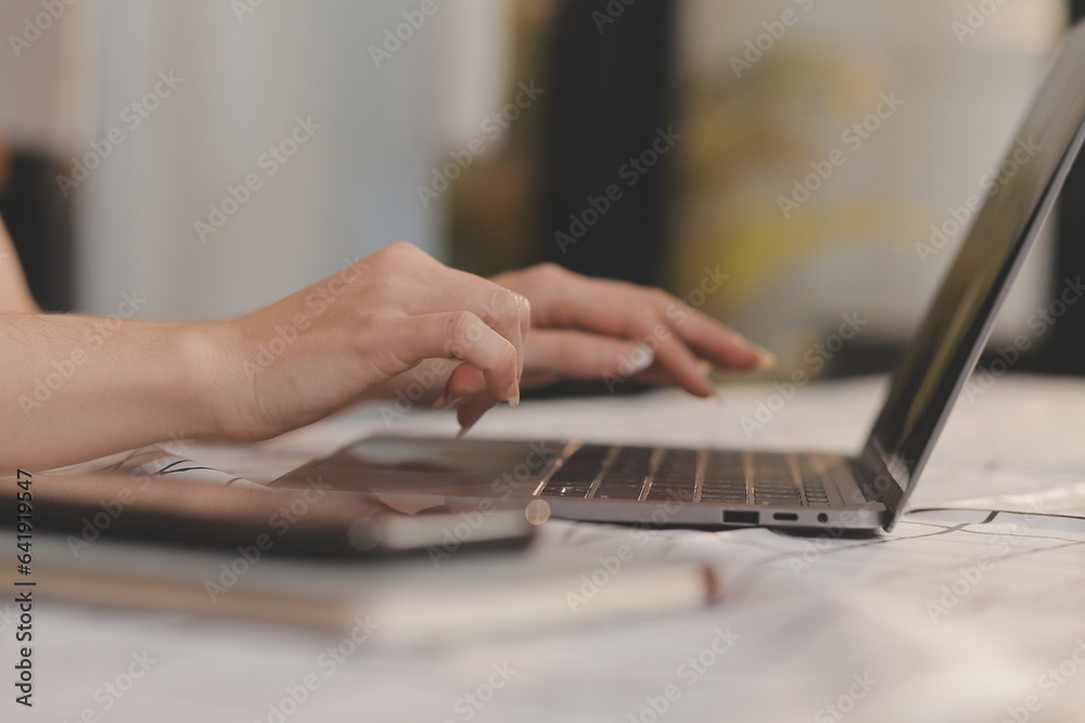 Cropped photo of Freelancer business Asian woman holding coffee cup and at doing planning analyzing the financial report, business plan investment, finance analysis the workplace. Cropped photo of Freelancer business Asian woman holding coffee cup and at doing planning analyzing the financial report, business plan investment, finance analysis the workplace.