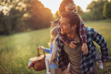 Young caucasian family having a picnic on a grassy field in nature