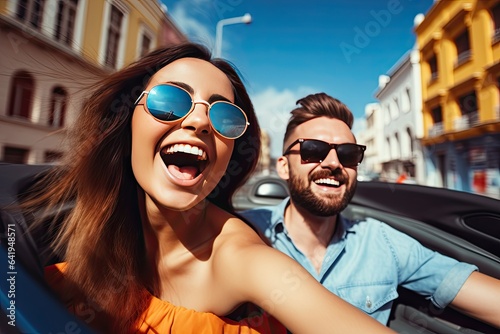 Happy young couple driving a convertible car on a city street. Summer vacation and travel concept