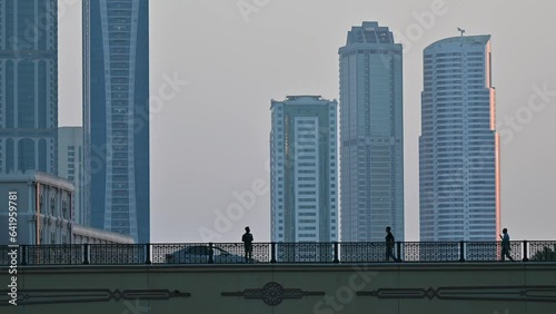 4k: People on the bridge, city traffic and modern residential towers in the background. photo