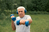 Senior man working out outdoors. Person lifting dumbbells. Old male exercising at park. Healthy people lifestyle. Active sport training. Older elderly sportsman doing fitness exercise. Workout session
