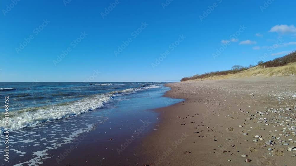 Calm beach walking on Baltic sea shore on sunny day Calm beach walking on Baltic sea shore on sunny day