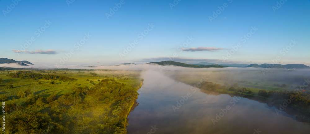 Morning fog and mist over river through green Northern Hokkaido landscape