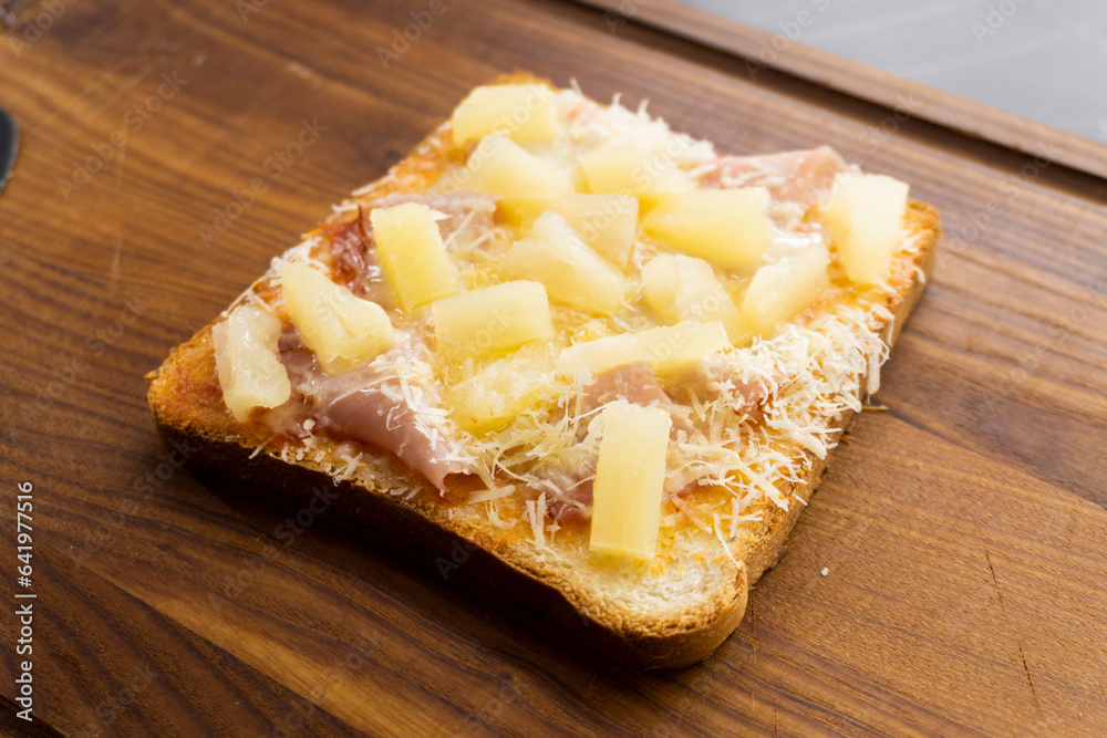 toast with ham and pineapple on a wooden background. sandwich. mini pizza. top view toast with ham and pineapple on a wooden background. sandwich. mini pizza. top view