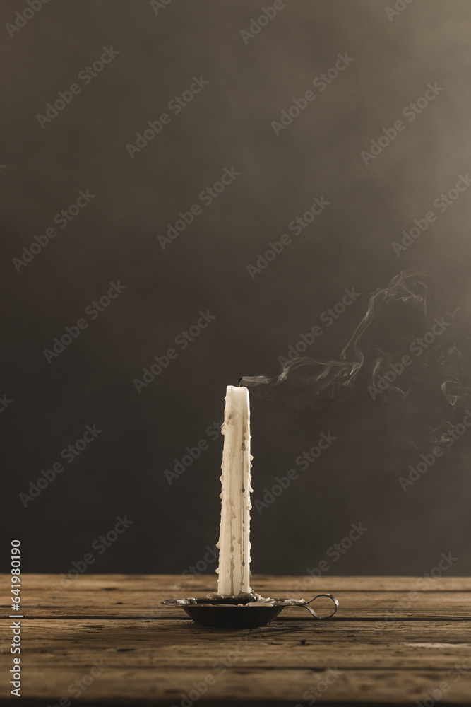 Fototapeta premium Vertical image of extinguished candle with copy space on grey background