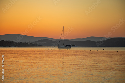 beautiful sunrise over Bodrum. clear sky and orange sun. boats sailiing on the sea