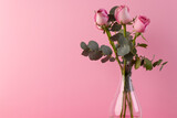 Pink rose flowers in glass vase and copy space on pink background