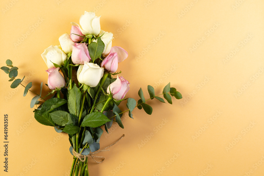 Obraz premium Bunch of pink and white rose flowers with copy space on orange background