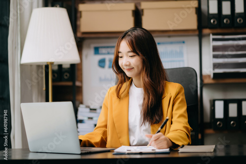 Business woman using tablet and laptop for doing math finance on an office desk, tax, report, accounting, statistics, and analytical research concept