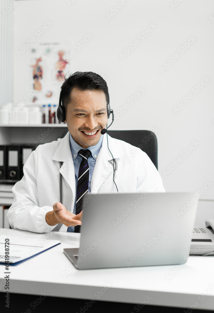 Caring asian therapist conducts video consultation, communicates with patient via an online conference, uses laptop, diagnoses, recommended and prescribed medications, and also answers questions. Caring asian therapist conducts video consultation, communicates with patient via an online conference, uses laptop, diagnoses, recommended and prescribed medications, and also answers questions.