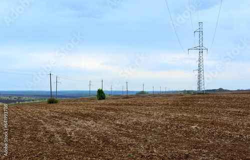 transmission line on the plowed agricultural field in rainy day copy space 