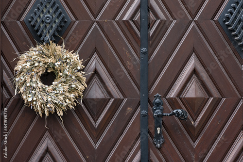 Circlet of dry flowers on old wooden gate