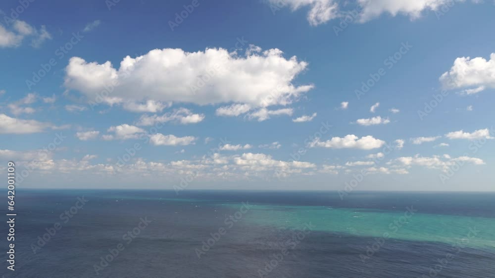 Aerial view on azure sea with fluffy Cumulus clouds moving in bright sunset sky over calm sea. Nature summer ocean sea beach background. Nobody. Weather and Climate Change. Holiday and travel concept Aerial view on azure sea with fluffy Cumulus clouds moving in bright sunset sky over calm sea. Nature summer ocean sea beach background. Nobody. Weather and Climate Change. Holiday and travel concept