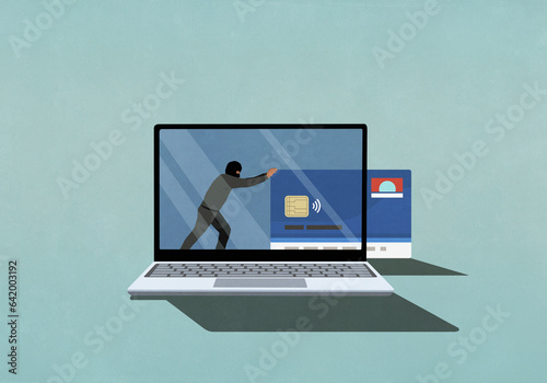 Computer hacker pushing credit card off laptop screen
 photo