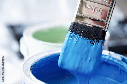 Close up of blue paint pot and dripping paintbrush
 photo