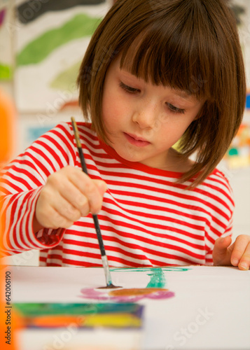 Portrait of young girl painting with watercolor
 photo