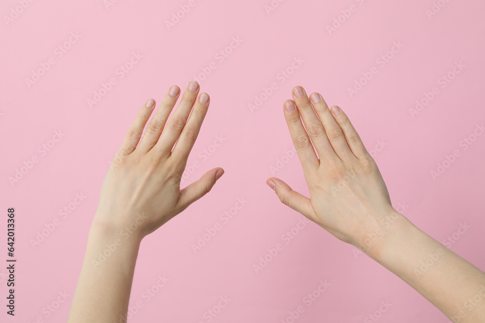 Female hands on a light pink background Female hands on a light pink background