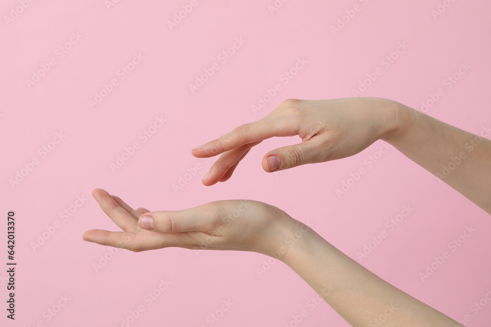 Female hands on a light pink background