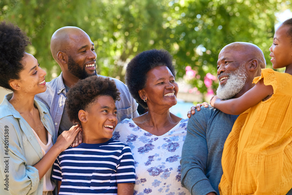 Portrait Of Multi-Generation Family Standing Outdoors In Garden Or Countryside Smiling At Camera Portrait Of Multi-Generation Family Standing Outdoors In Garden Or Countryside Smiling At Camera