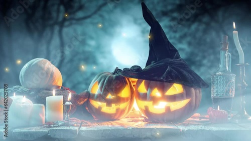 Two carved pumpkins in witch hats lying on table with many candles over dark, foggy forest background. Spooky season. Concept of autumn holiday, Halloween, traditions, mystery, surrealism photo