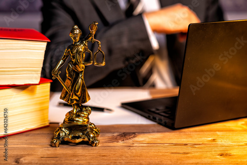 office of a lawyer with statue of Lady Justice, goddess Justitia, on the desk photo