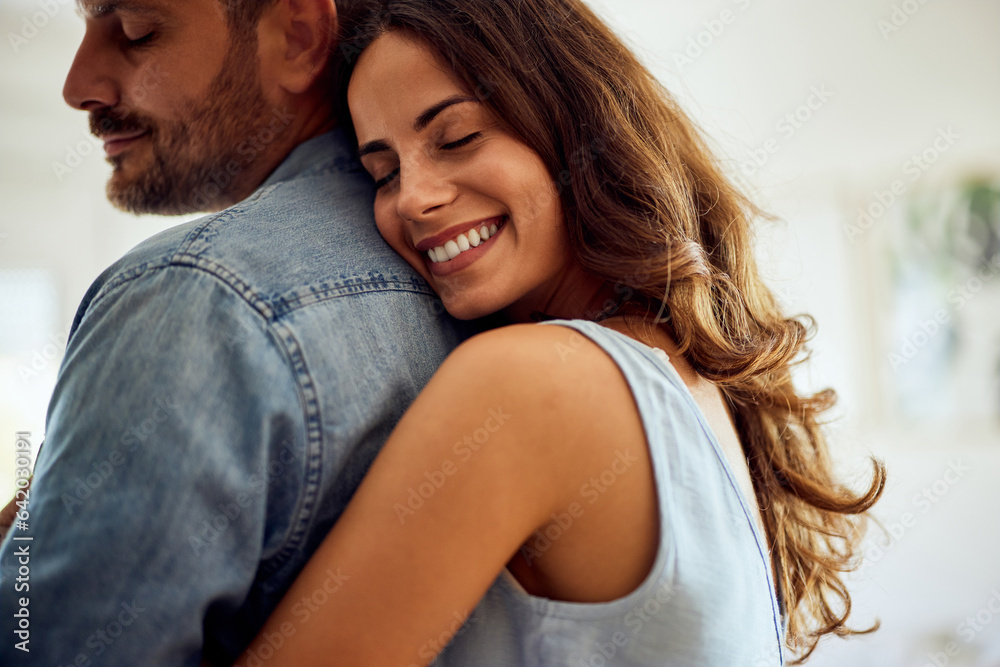A close-up of a smiling woman giving her boyfriend a hug from the back. A close-up of a smiling woman giving her boyfriend a hug from the back.