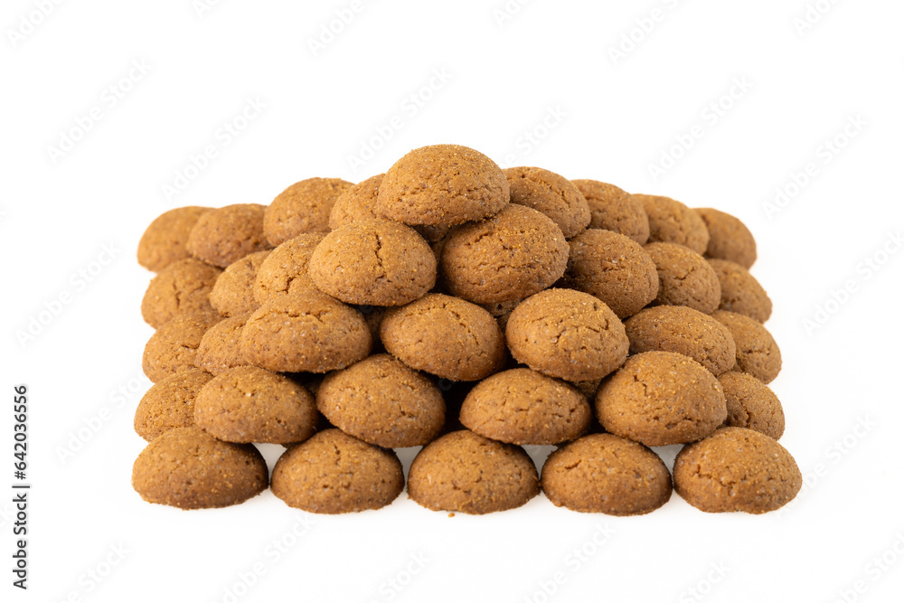 Kruidnoten are crunchy biscuits with gingerbread spices, which are often eaten during the Sinterklaas celebration in the Netherlands. Pyramid of spice nuts from above on a white background.