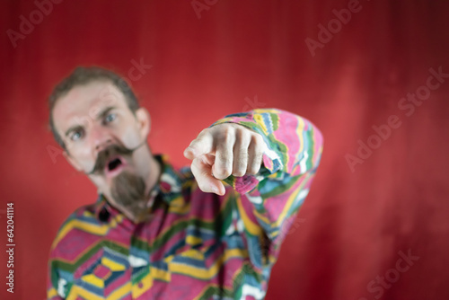 Angry hipster man pointing at camera shouting and with furious expression