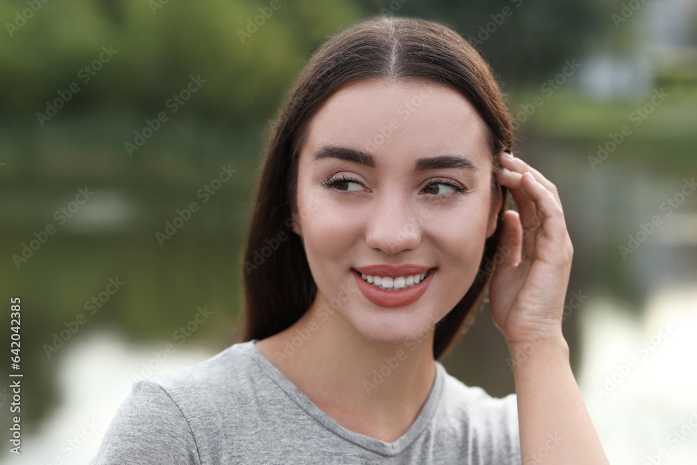 Portrait of beautiful woman outdoors. Attractive lady smiling and posing for camera Portrait of beautiful woman outdoors. Attractive lady smiling and posing for camera